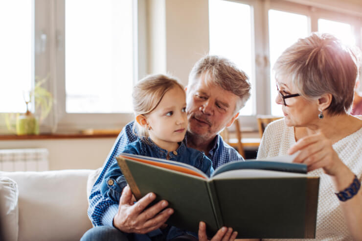 Storytelling Older couple reading book to young girl