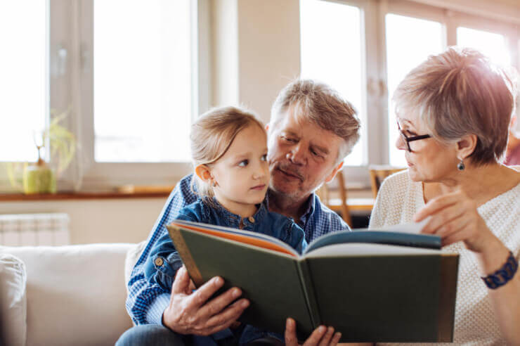 Storytelling Older couple reading book to young girl