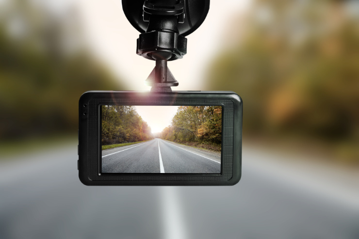 Photo of dashcam showing forested road ahead with a blurred background